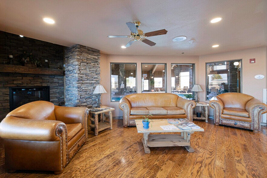 Wide lobby lounge with stone fireplace and pool deck windows